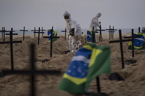 Activists in costume from the NGO Rio de Paz dig symbolic graves on Copacabana beach to protest the government's handling of the COVID-19 pandemic in Rio de Janeiro, Brazil, Thursday, June 11, 2020. (Photo | AP)