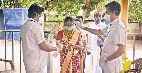 File photo of health officials screening the bride and bridegroom for Covid-19 symptoms before the wedding at Guruvayur on Friday