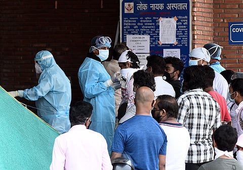 Medical workers in PPE gear interacting with visitors outside the Covid-19 ward at Lok Nayak Jai Prakash Narayan Hospital LNJP on June 12 2020 in New Delhi. (Photo | Parveen Negi/EPS)