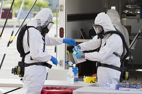 Army National Guard members bag a nasal swab at drive-thru COVID-19 testing at Highland High School, Thursday, May 21, 2020 in Cowiche, Washington. (Photo | AP)