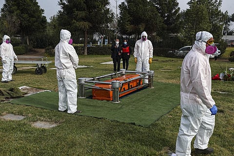 Cemetery workers wearing protective gear against the new coronavirus, walk after carrying the coffin of 72-year-old Monica Lagos to her grave at the Manantial cemetery in Santiago, Chile, Monday, June 15, 2020. (Photo | AP)