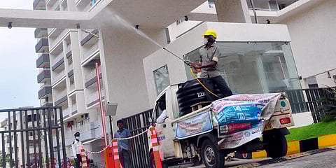 Workers disinfecting a high-rise in Visakhapatnam on Thursday. (Photo| G Satyanarayana, EPS)
