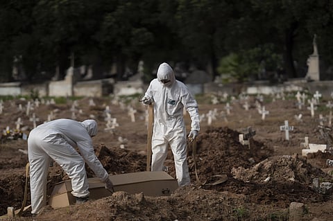 Health workers in PPE burying a person who died due to COVID-19. (Photo | AP)