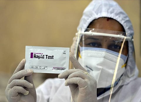 A medic shows a Rapid Test kit for COVID-19 tests at a testing centre in a government school in New Delhi on Friday. (Photo | PTI)