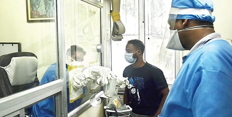 Doctors at a private clinic attend to patients in makeshift swab-collection booths | VINAY MADAPU