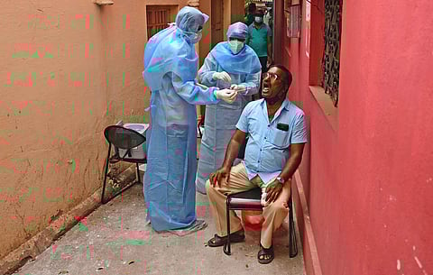 Health workers collect swab samples from the primary contacts of a Covid-positive police officer, in Bengaluru. (Photo | Shriram BN, EPS)