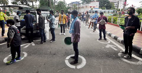 Migrants wait in queues to receive rice being distributed by the Kamrup administration outside the Guwahati Railway Station during ongoing COVID-19 lockdown in Guwahti Wednesday June 3 2020. (Photo | PTI)