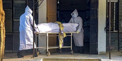 Health workers moving the deceased body of a COVID-19 victim. (File Photo | PTI)