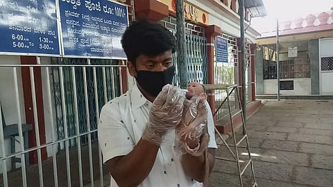 Prasanna Kumar  takes care of a  baby monkey that was rescued