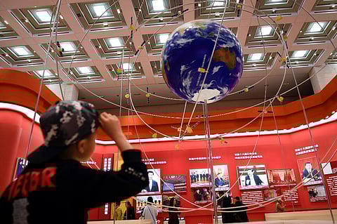 A boy looks at the BeiDou Navigation Satellite System at an exhibition. (Photo | AFP)