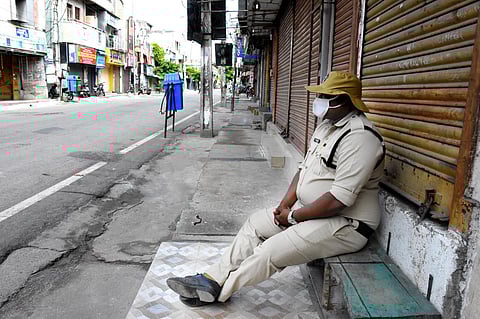 A police officer rests on the pavement. (Photo| EPS/ madhav K)