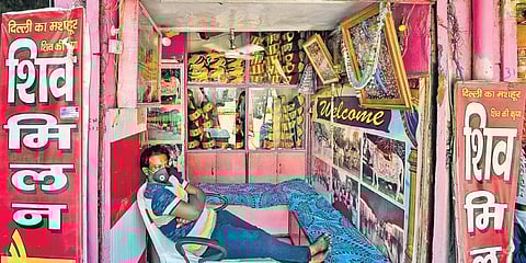 A shopkeeper waits for customers at his wedding band shop in New Delhi. (Photo | PTI)