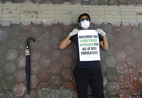 A protesters lies on the ground demanding better handling of the COVID-19 pandemic in Kathmandu. (Photo | AP)