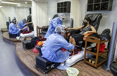 Beauticians wearing protective gear attend customers at a salon inside a mall after it reopened during ongoing COVID-19 lockdown in Ahmedabad Monday June 8 2020. (Photo | PTI)