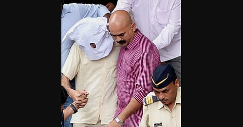 Sanjeev Khanna the former husband of Indrani Mukherjea arrested in connection with the Sheena Bora murder case is escorted out of Bandra Metropolitan Magistrate after he was produced in Mumbai on Friday.  (File Photo | PTI)