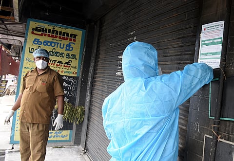 Health workers from Cantonment Board pasting a home quarantine sticker at Butt road in St Thomas Mount. (Photo | Martin Louis/EPS)
