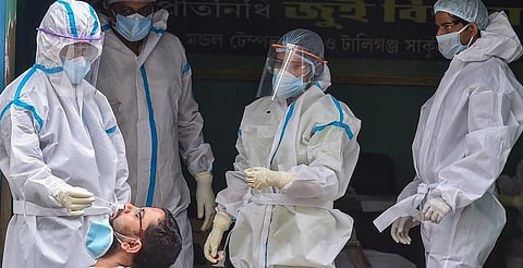 A health worker collects swab sample of a person for COVID-19 test at a center in Kolkata. (Photo | PTI)