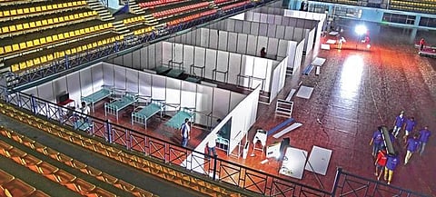 Workers arrange beds for patients at the Covid Care Centre set up by the BBMP at the Koramangala Indoor Stadium In Bengaluru on Sunday | shriram BN