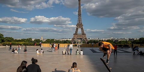 People stroll at Trocadero square near the Eiffel Tower in Paris. (Photo | AP)