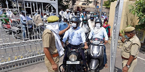 Security personnel check the temperature of employees on the entrance gate of Uttar Pradesh secretariat building in Lucknow during the COVID-19 lockdown. (File photo| ANI)