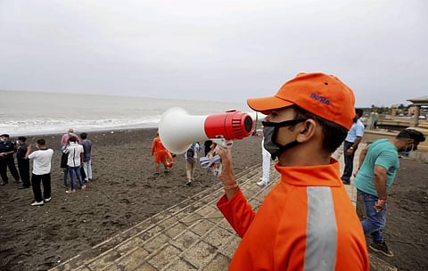 An NDRF official makes warning announcments in Mumbai's Versova Beach on Wednesday. (Photo | PTI)
