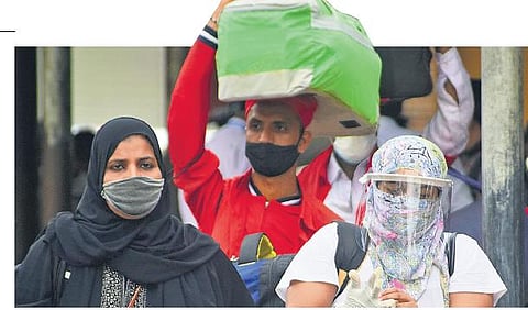 Passengers who arrived from Mumbai by Udyan Express come out  of KSR railway station in Bengaluru  on Tuesday;