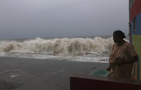 A woman watches waves splash on shores of the Arabian Sea in Mumbai. (Photo | AP)
