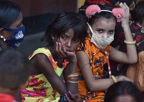 A family waits outside Howrah Station to board a special train for Patna during ongoing fifth phase of the COVID-19 lockdown in Kolkata. (Photo | PTI)