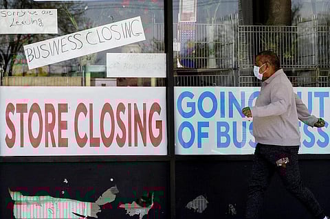 FILE - In this May 21, 2020 file photo, a man looks at signs of a closed store due to COVID-19 in Niles, Ill. (Photo | AP)