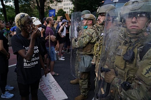 Soldiers with Utah National Guard stand near a group of demonstrators that gathered to protest the death of George Floyd, Wednesday, June 3, 2020, near the White House in Washington. Floyd died after being restrained by Minneapolis police officers. (Photo