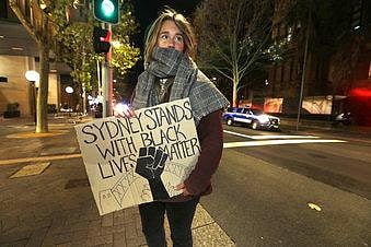 A protester from St. Louis, U.S., who gave her name as Merinda, carries a handmade sign as demonstrators gather in Sydney, Tuesday, June 2, 2020, to support the cause of U.S. protests over the death of George Floyd and urged their own governments to addre