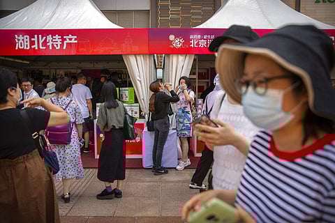 In this Saturday, June 6, 2020, photo, people wearing face masks to protect against the new coronavirus browse merchant tents at a government event aiming to stimulate consumer demand and consumption in Beijing. (Photo | AP)