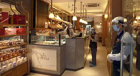 A restaurant worker wearing a protective face mask and shield against the spread of coronavirus waits for customers at L'Opera restaurant in New Delhi on Saturday.  (Photo | Shekhar Yadav/EPS)