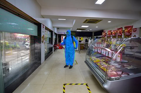 A worker wearing a PPE suit sanities a restaurant ahead of its reopening tomorrow during the ongoing COVID-19 nationwide lockdown in Bengaluru Sunday June 7 2020. (Photo | PTI)