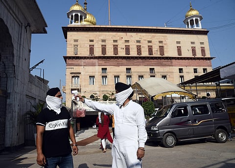 A sikh devotee being screened with thermal device at Sis Ganj Gurudwara during the ongoing COVID-19 nationwide lockdown in New Delhi on Sunday June 7 2020.  (Photo | Parveen Negi/EPS)
