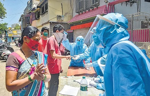 Volunteers carry out thermal tests of residents at Dharavi in Mumbai | pti