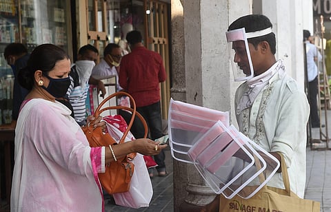 A woman buys face shield from a hawker during the fifth phase of COVID-19 lockdown in Kolkata Friday June 5 2020. (Photo | PTI)