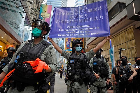 Police display a public announcement banner showing the warning to protesters in Causeway Bay before the annual handover march in Hong Kong (Photo | AP)