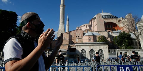 A Muslim man prays, following Turkey's Council of State's decision, outside the Byzantine-era Hagia Sophia in Istanbul. (Photo| AP)