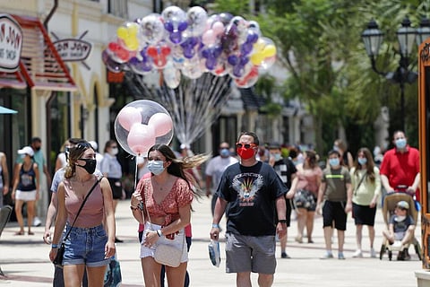 n this June 16, 2020, file photo, guests required to wear masks because of the coronavirus stroll through the Disney Springs shopping, dining and entertainment complex in Lake Buena Vista, Fla. Magic Kingdom and Animal Kingdom will reopen on July 11. (Pho