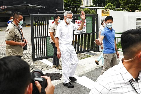 People's Action Party Secretary-General and Singaporean Prime Minister Lee Hsien Loong, center, wearing a mask, waves as he departs the Alexandra Primary School polling center after casting his vote in Singapore, Friday, July 10, 2020. (Photo | AP)