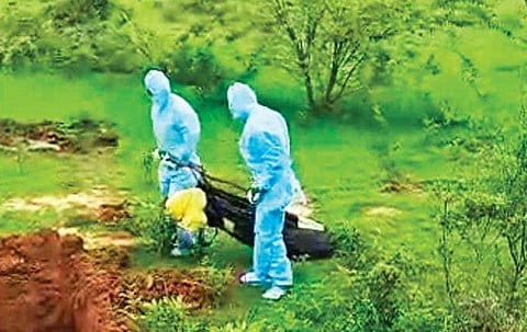 (Image for representation) Healthcare workers drag a dead body into a burial pit in Wadageri taluk. (Video Screengrab)