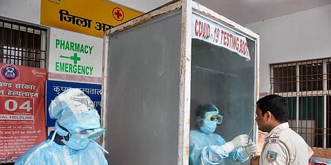 A health worker collects sample from a policeman for COVID19 test at the District Hospital in Ranchi. (Photo | PTI)