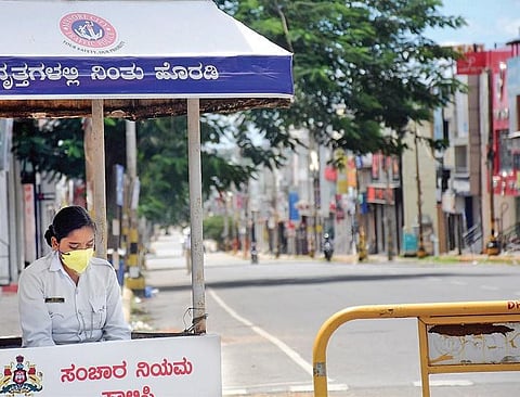 A traffic police constable wears a mask while on duty at DD Urs Road, Mysuru, during Sunday’s state-wide lockdown. (Photo | EPS/Udayshankar S)