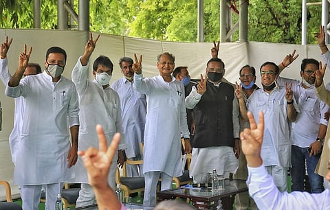 In a display of strength, CM Ashok Gehlot poses with MLAs at the meeting at his residence. (Photo | PTI)