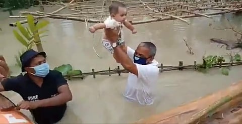 BJP MLA Mrinal Saikia resucing a child in a flood-hit village in his Khumtai constituency (Photo | Twitter/@MrinalS66742364EPS)