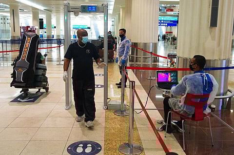 In this June 10, 2020 file photo, passenger wearing a mask due to the coronavirus pandemic passes through a temperature screening at Dubai International Airport's Terminal 3 in Dubai, United Arab Emirates. (Photo | AP)