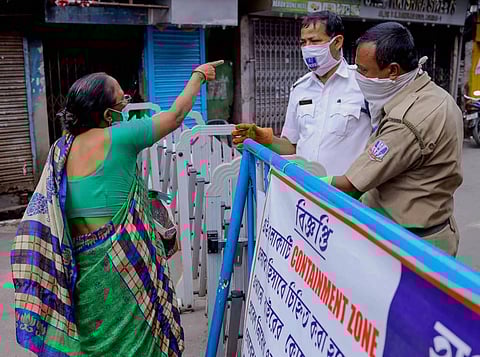 Policemen stop a commuter from entering at sealed residential area after the state government imposed total lockdown in all containment zones follwing a surge in COVID 19 cases in Howrah Monday July 13 2020. (Photo | PTI)
