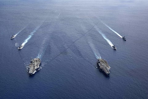 In this photo provided by U.S. Navy, the USS Ronald Reagan (CVN 76) and USS Nimitz (CVN 68) Carrier Strike Groups steam in formation, in the South China Sea, Monday, July 6, 2020. (Photo | AP)