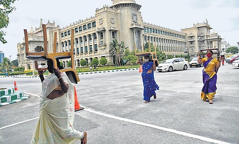 Vidhana Soudha staffers move chairs and other equipment to the